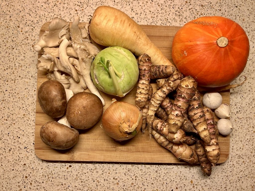 Verse ingrediënten voor vergeten groentensoep: aardpeer, paddestoelen, ui, koolrabi, pompoen en knoflook